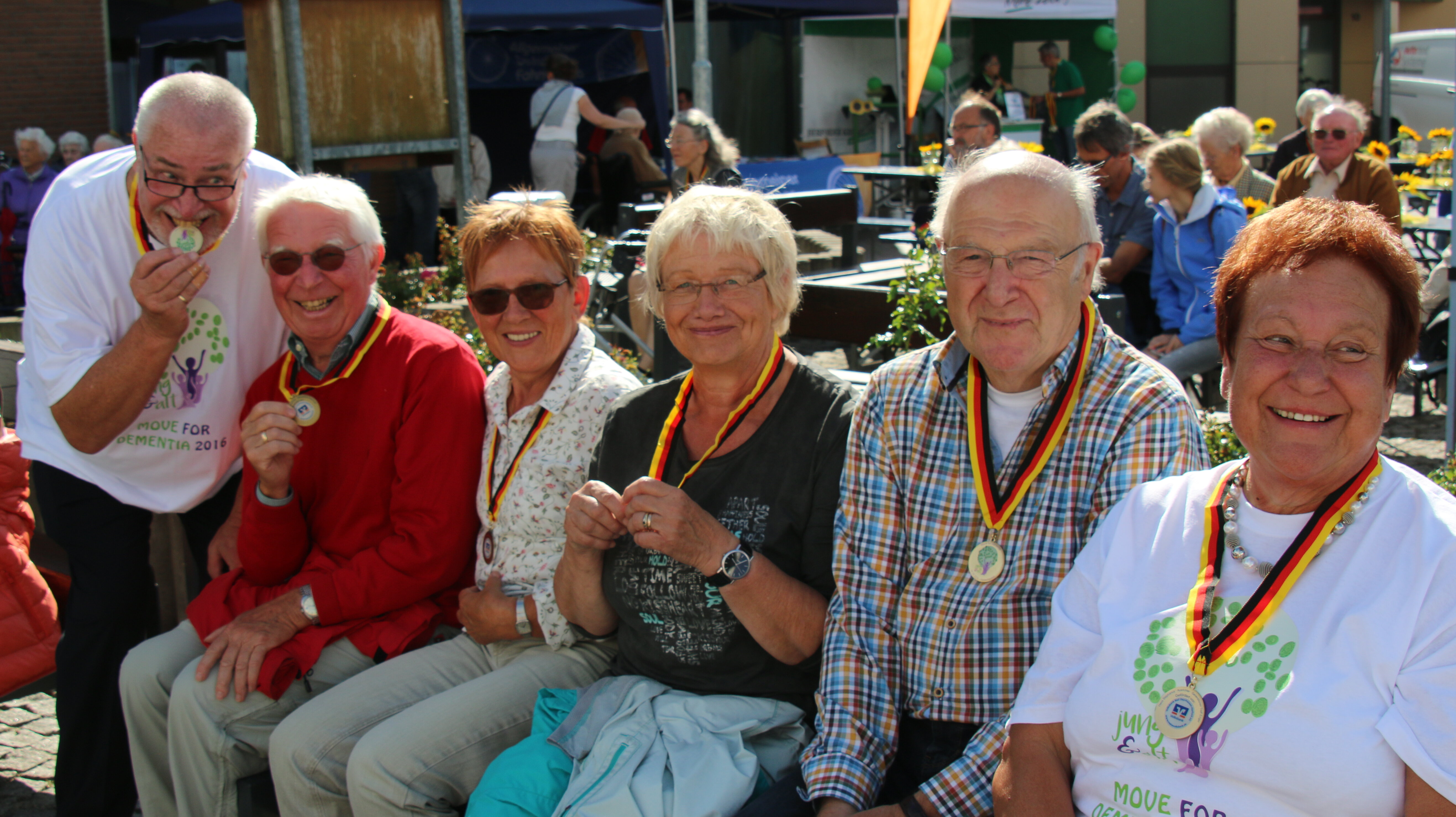 Auf diesem Foto sieht man eine kleine Gruppe älterer Menschen. Alle haben eine Medaille um den Hals. 