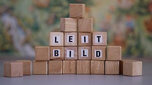 Holzklötzchen mit Buchstaben, die den Begriff "Leitbild" bilden