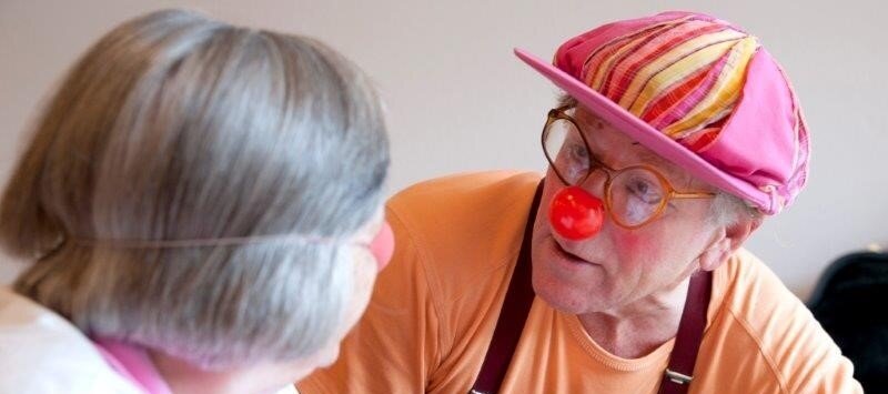 Foto: Ein Mann verkleidet als Clown und eine ältere Dame.