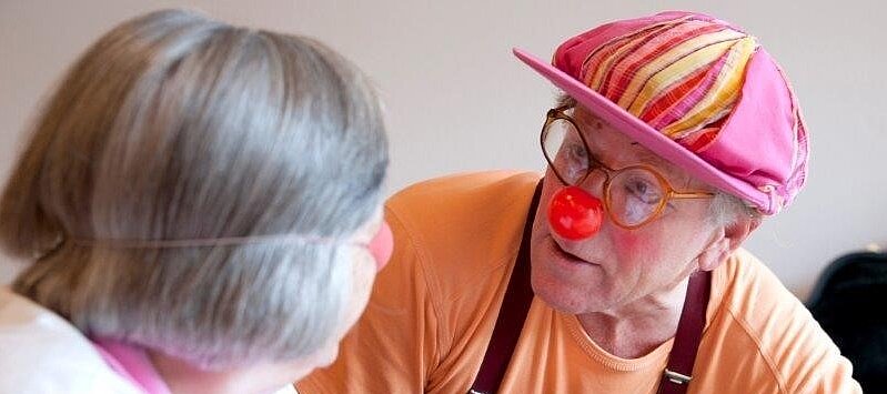 Foto: Ein Mann verkleidet als Clown und eine ältere Dame.