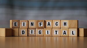 Holzklötzchen mit Buchstaben, die die Worte "Einfach digital" bilden. 
