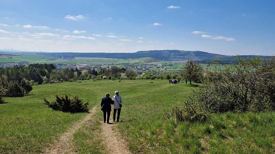 Foto: Zwei Seniorinnen Arm in Arm auf einen Feldweg 