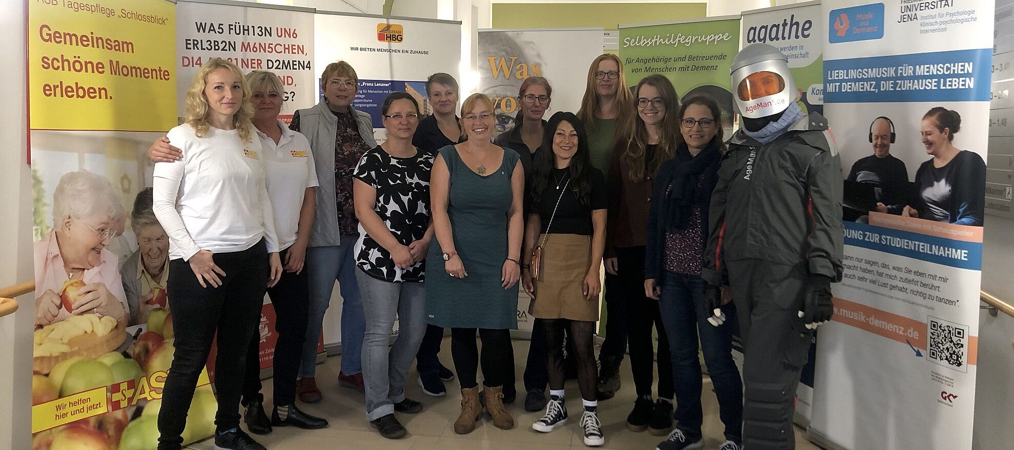 Foto: Eine Gruppe Menschen steht in einem Flur zwischen Stellwänden