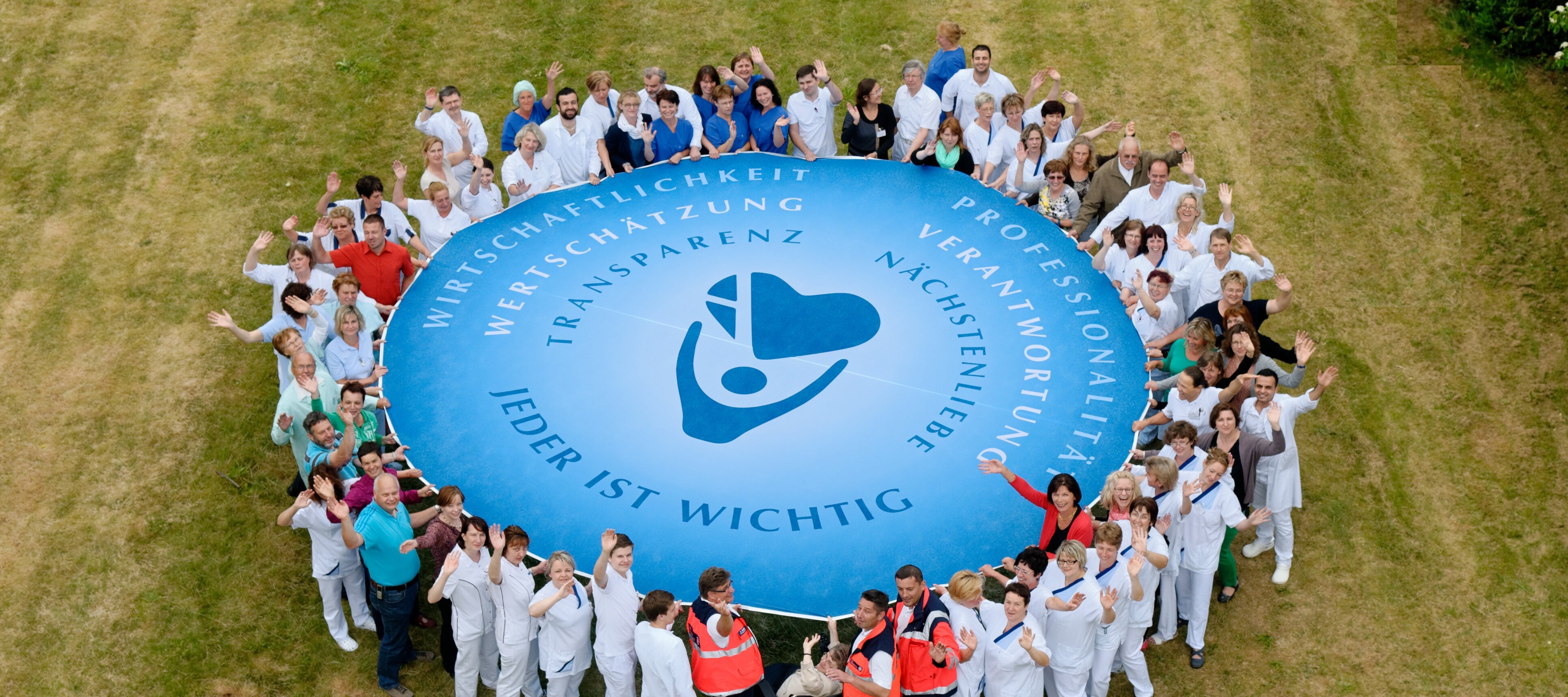 Krankenhaus Mitarbeiter/innen mit Schwungtuch von oben.