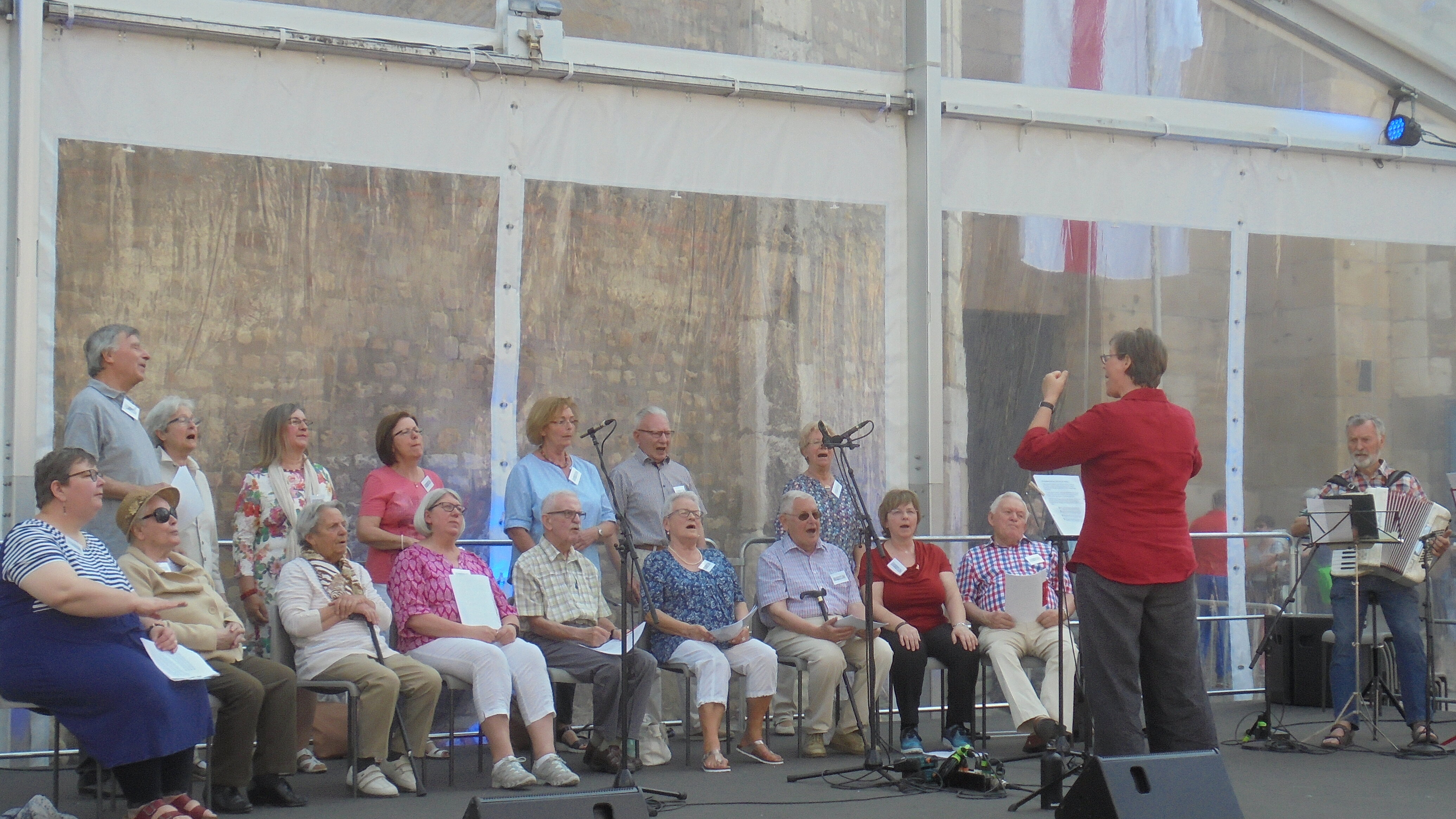 {© Demenzzentrum Trier Chorauftritt auf einer Bühne mit Dirigentin