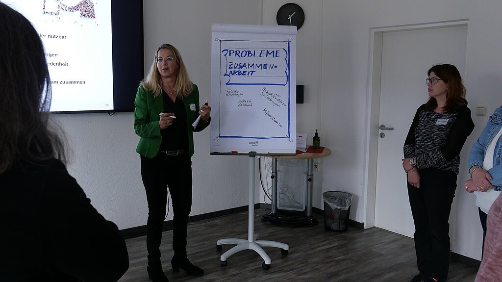 Nicola Richter steht vor einem Flipchart und spricht zu den Teilnehmenden