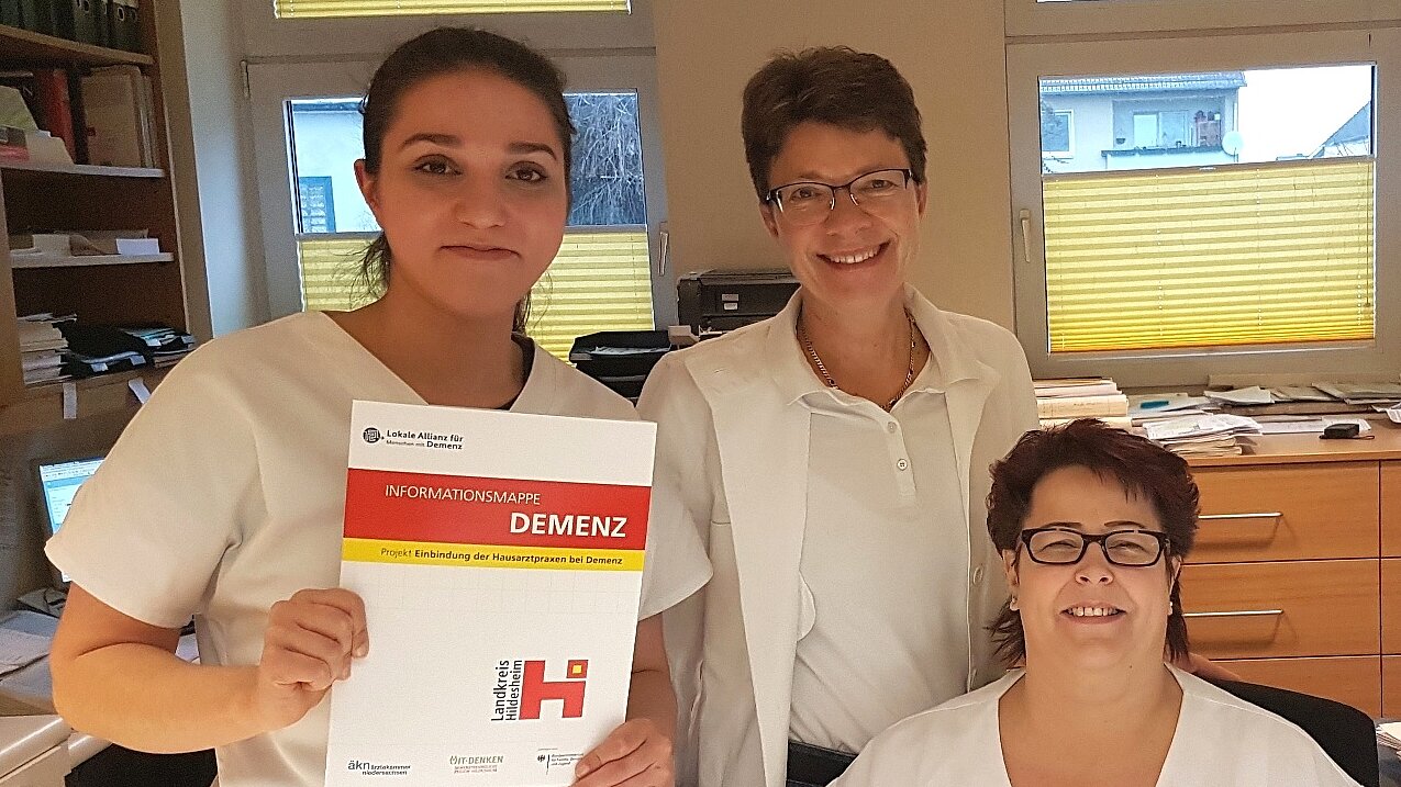 Drei Praxismitarbeiterinnen mit den Informationsmappen "Demenz" 