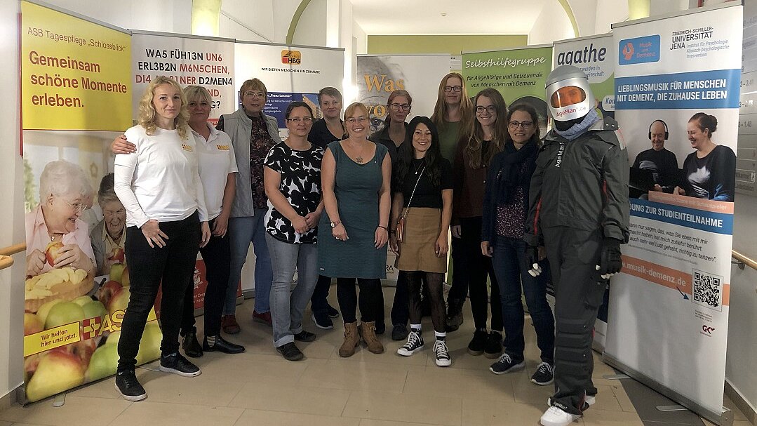 Foto: Eine Gruppe Menschen steht in einem Flur zwischen Stellwänden