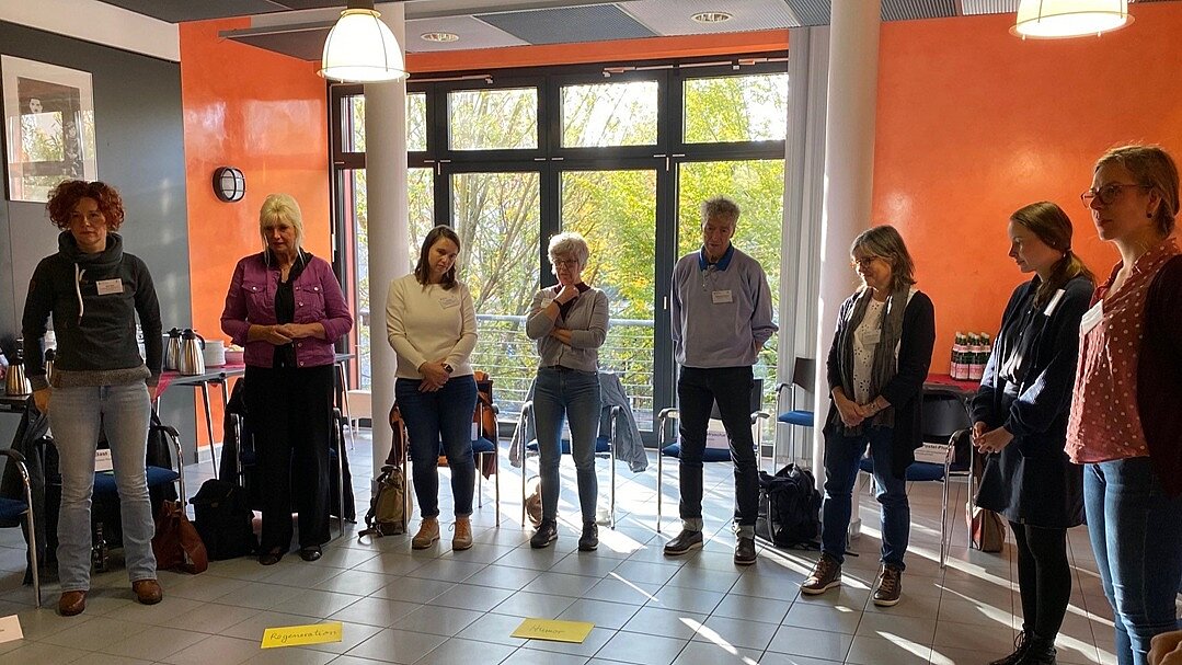 Die Teilnehmenden stehen in einem Halbkreis