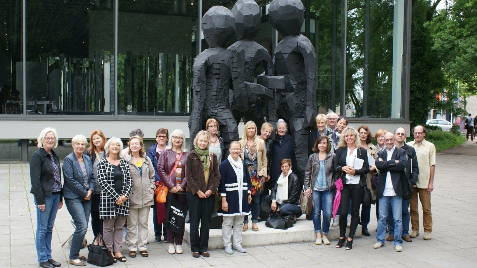 Eine Gruppe von Menschen (Kulturbegleitern) steht vor dem Lehmbruck Museum 