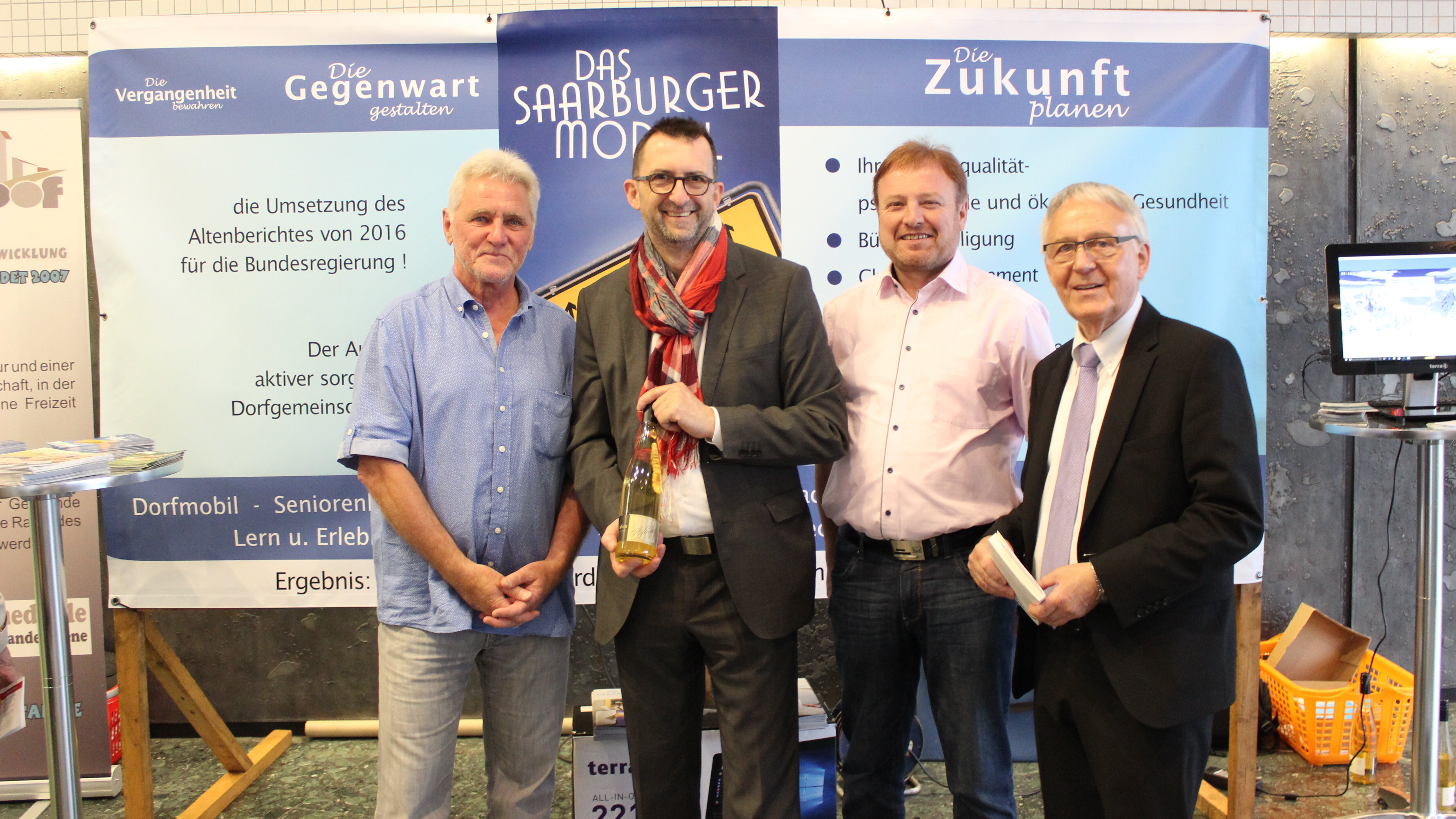 Teilnahme an der Gesundheitsmesse Salut in Saarbrücken, 2018 (Zweite Person von links: Reinhold Jost, Minister für Umwelt und Verbraucherschutz) Foto: Die Projektbeteiligten stehen mit Reinhold Jost vor einer Stellwand