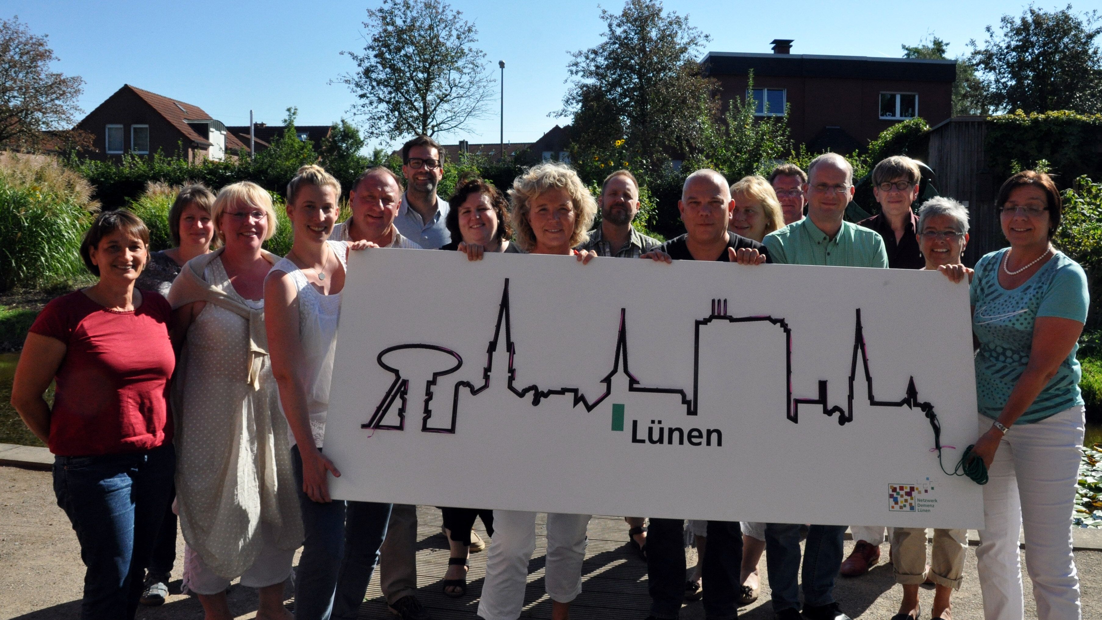 Auf diesem Foto sehen Sie viele Personen, die ein Schild mit der Stadtsilhouette von Lünen hochhalten