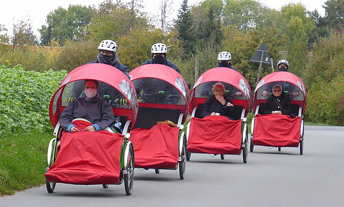 Personen, die in Rikschas gefahren werden.