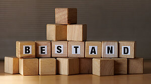 Holzklötzchen mit Buchstaben, die den Begriff "Bestand" bilden