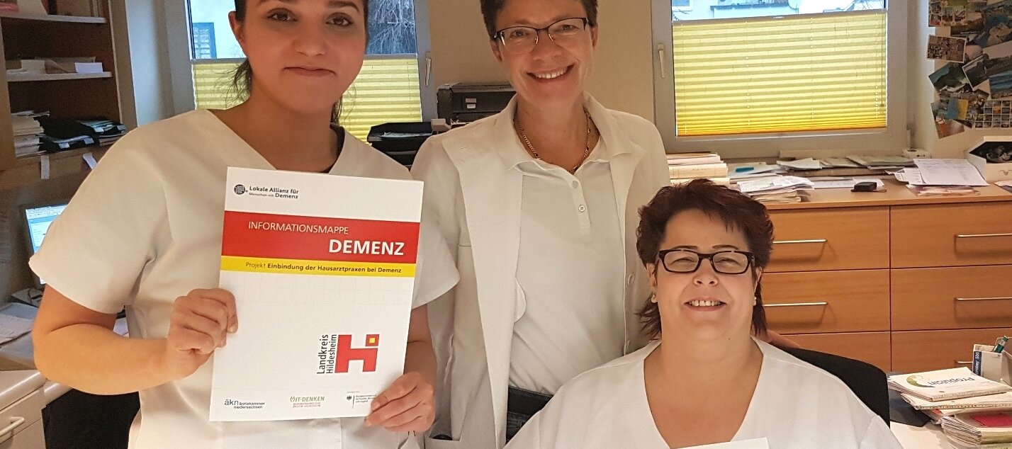 Drei Praxismitarbeiterinnen mit den Informationsmappen "Demenz" 