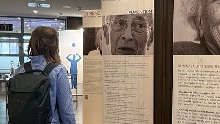 Johanna tr Kronnie vor Infotafeln zum Thema Demenz zur biög