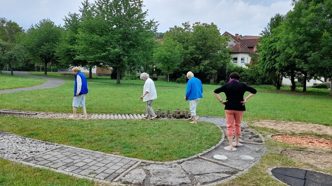 Seniorinnen gehen über einen Barfußpfad