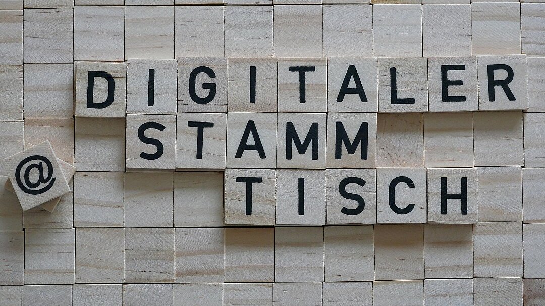 Der Begriff "Digitaler Stammtisch" gelegt aus Holzplättchen mit schwarzen Buchstaben