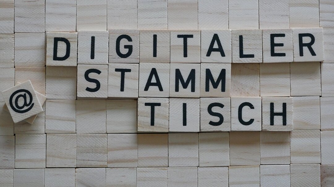 Der Begriff "Digitaler Stammtisch" gelegt aus Holzplättchen mit schwarzen Buchstaben