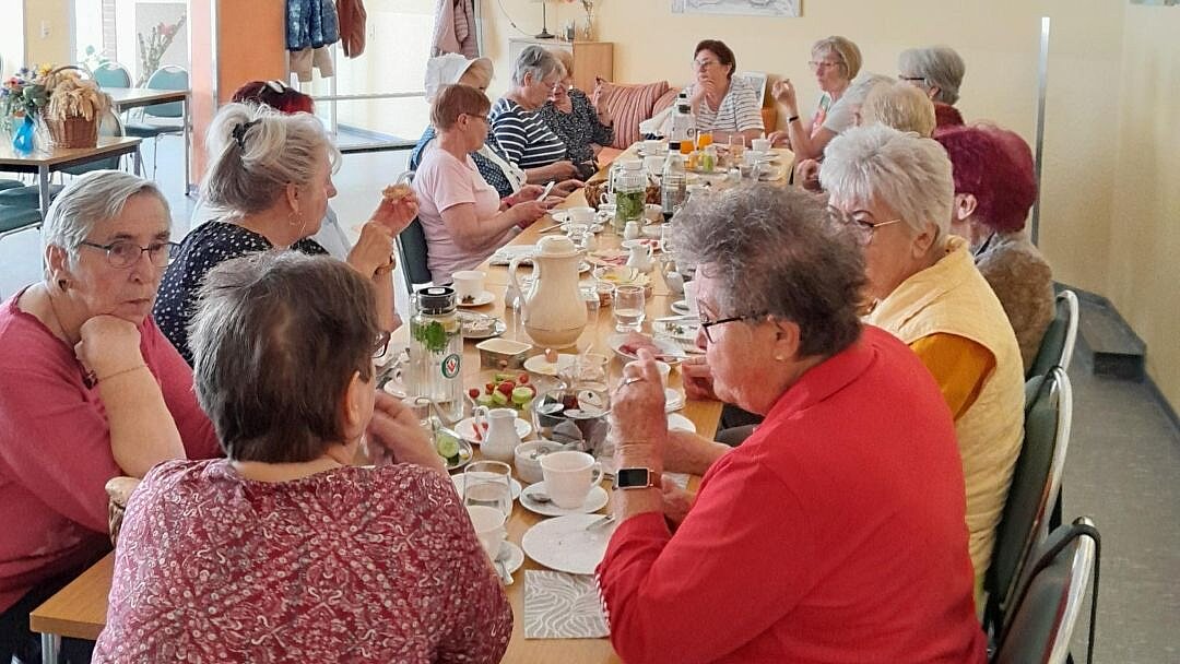 Seniorinnen frühstücken an einem reich gedeckten Tisch