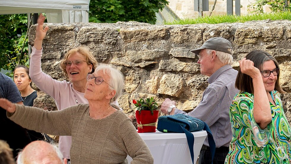 Foto: tanzende Senioren vor einer Mauer im Freien