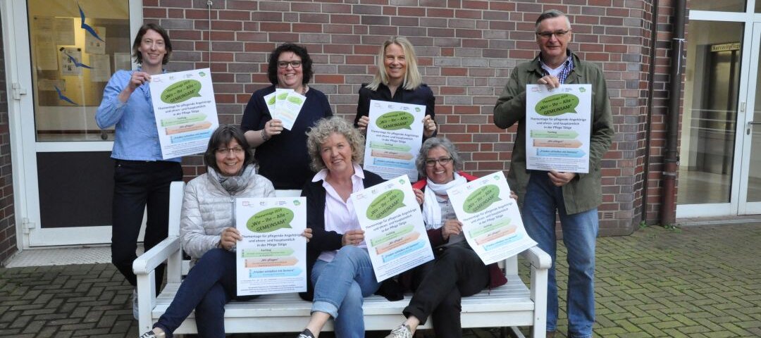 Auf diesem Foto sehen Sie eine mehrere Personen, die Plakate hochhalten