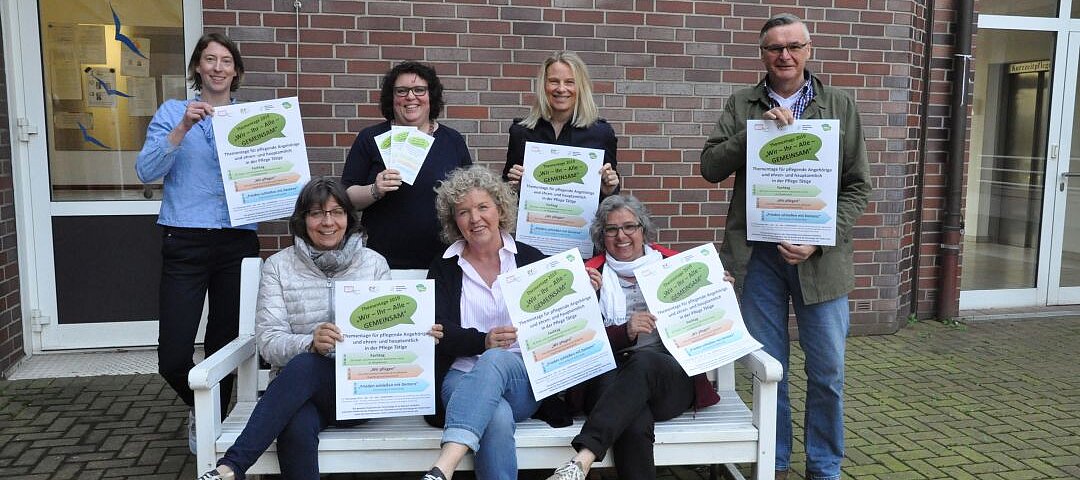 Auf diesem Foto sehen Sie eine mehrere Personen, die Plakate hochhalten