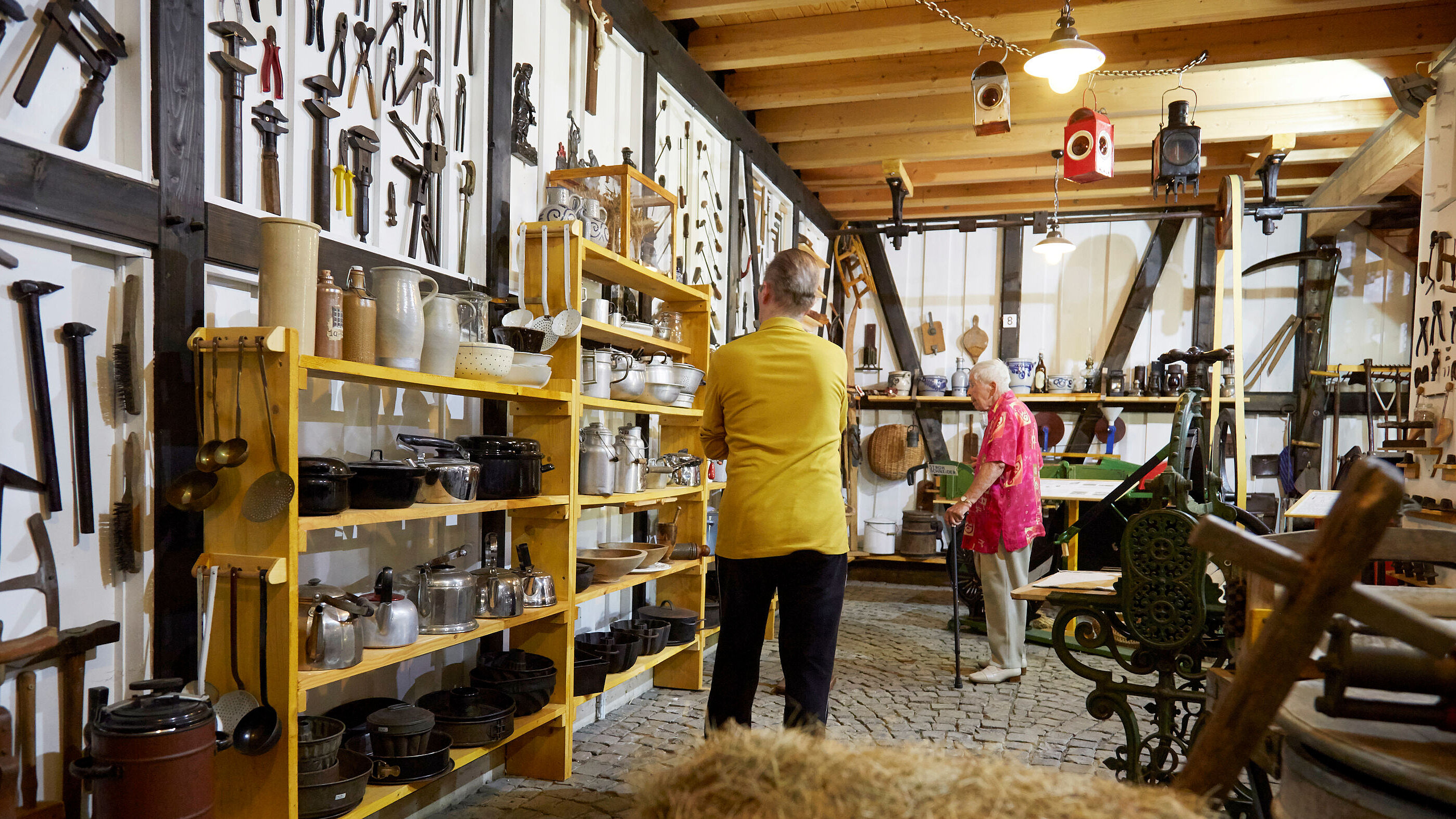 Foto: Auf dem Foto schauen sich zwei Senioren eine Ausstellung von alten Töpfen an