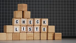 Holzklötzchen mit Buchstaben, die den Begriff "Checkliste" bilden