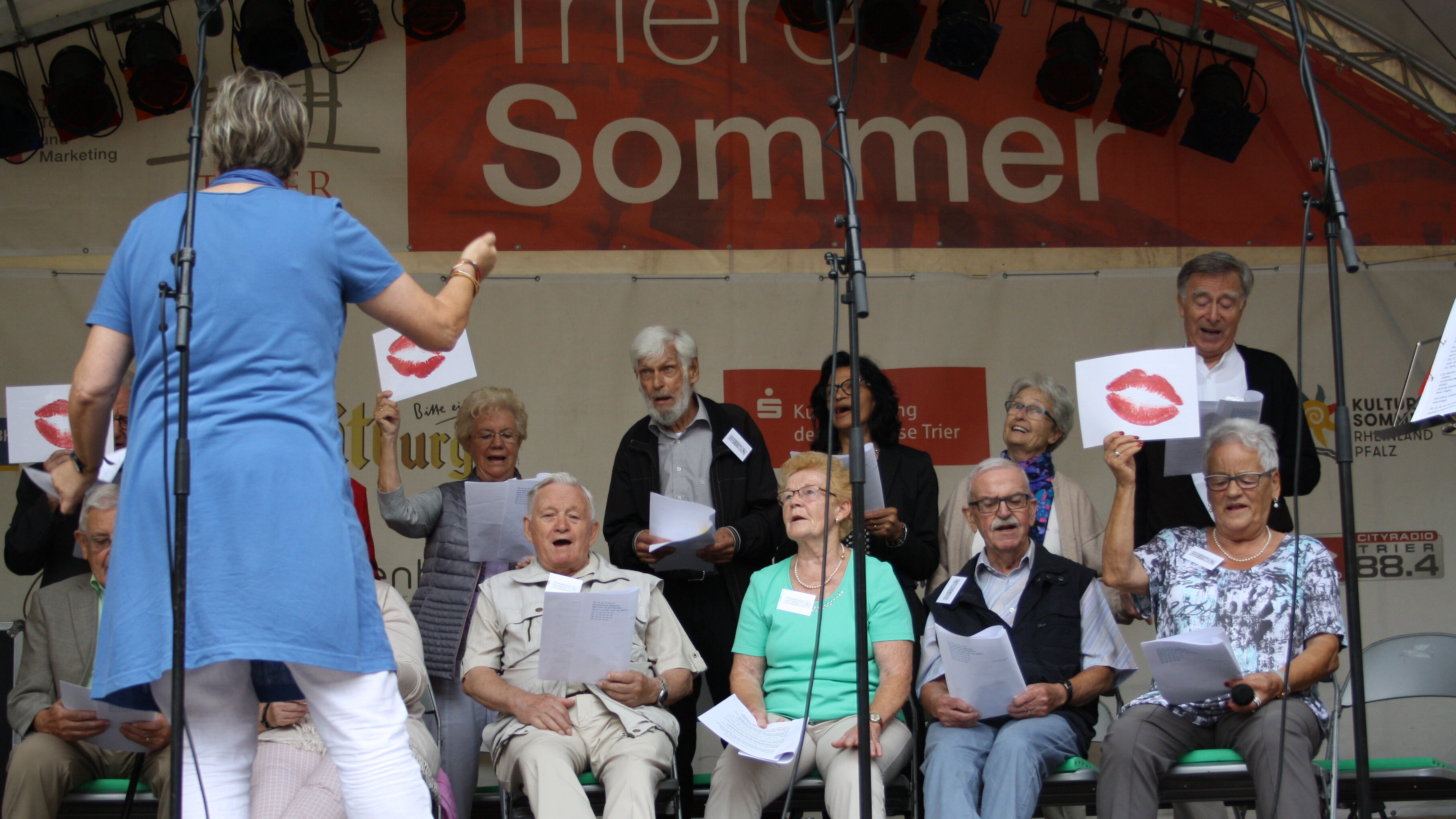 Foto von Sängerinnen und Sängern mit einer Dirigentin