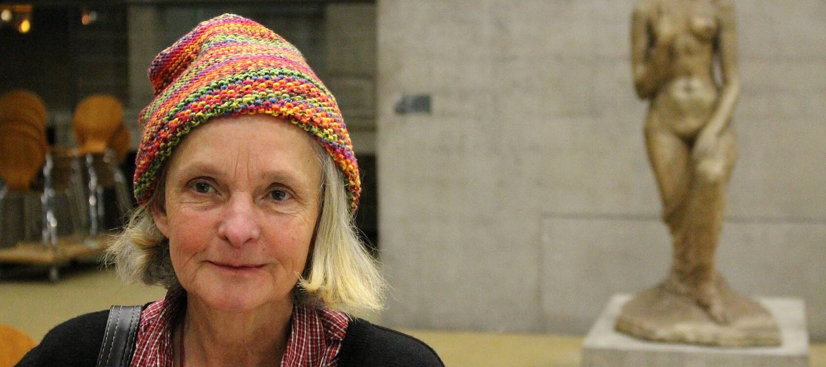 Foto: Im Vordergrund dieses Fotos sieht man eine ältere Museumsbesucherin, im Hintergrund steht eine Skulptur