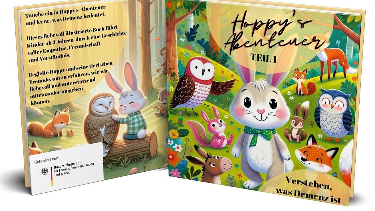Foto: Kinderbuch-Umschlag "Hoppy's Abenteuer". Vorderseite: Illustration eines kleinen grauen Häschens mit weißer Brust und grüner Schleife um den Hals umringt von anderen kindlich dargestellten Waldtieren auf einer Waldlichtung. Rückseite mit Infotext und Illustration von Häschen und Eule auf Baumstamm sitzend.