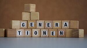 Holzklötzchen mit Buchstaben, die den Begriff "Generationen" bilden