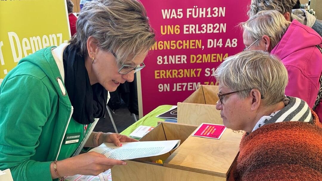 Zwei Frauen führen ein Gespräch am Messestand
