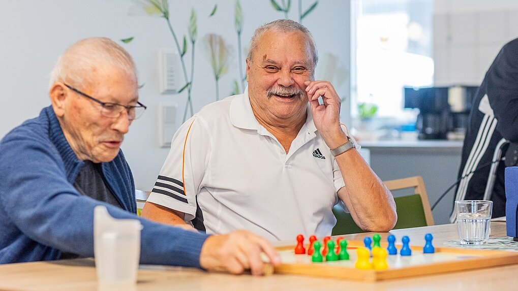 © LSJV/Möbus Zwei ältere Männer sitzen am Tisch und spielen "Mensch ärgere Dich nicht"