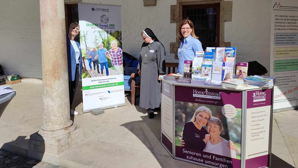 Foto: Messestand der Lokalen Allianz mit neuem Roll-Up auf dem überdachten Vorplatz einer Kirche
