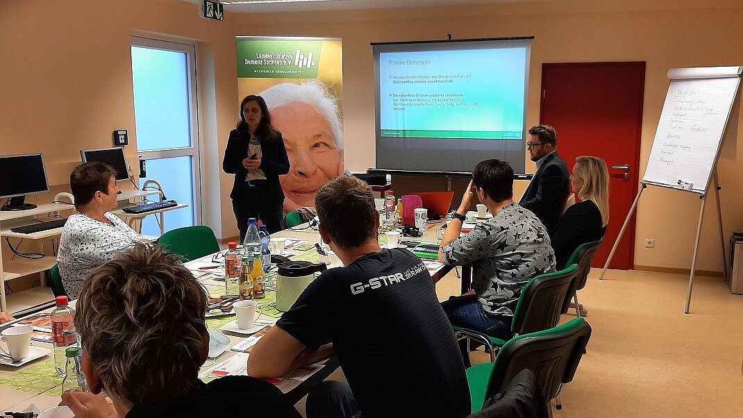 Demenznetz Delitzsch Foto: Personengruppe bei einer Präsentation mit Vortrag.