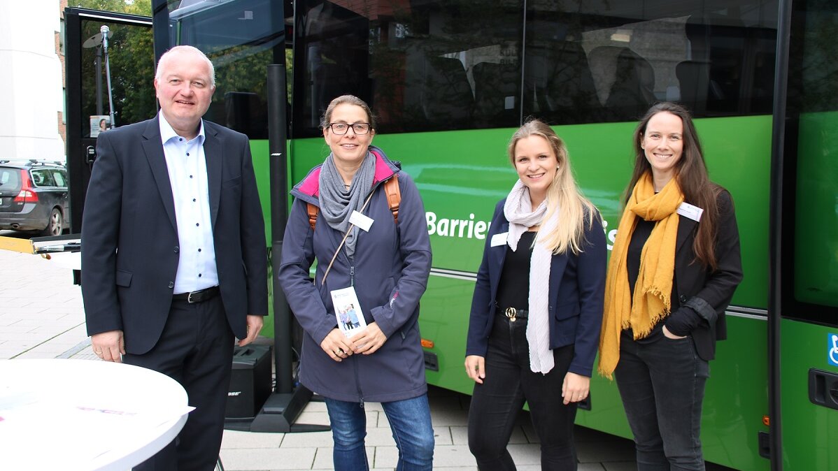 Foto: Der Landrat Dr. Henning Görtz steht mit Mitgliedern der Lokalen Allianz vor einem grünen Bus