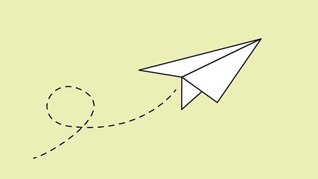 Weißer Papierflieger auf hellgrünem Hintergrund