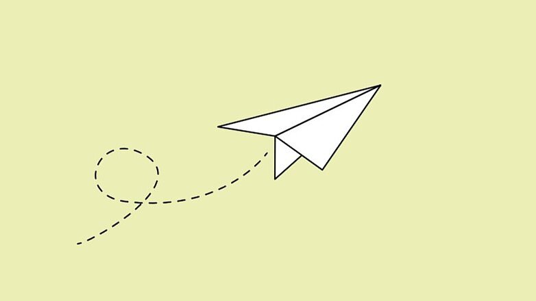 Weißer Papierflieger auf hellgrünem Hintergrund