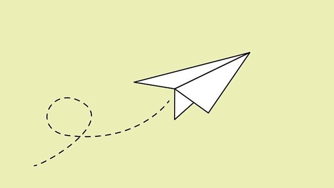 Weißer Papierflieger auf hellgrünem Hintergrund