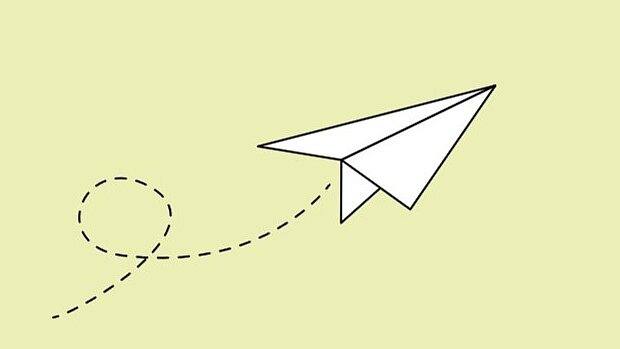 Weißer Papierflieger auf hellgrünem Hintergrund