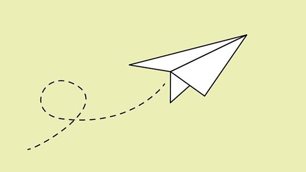 Weißer Papierflieger auf hellgrünem Hintergrund