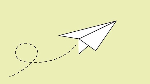 Weißer Papierflieger auf hellgrünem Hintergrund