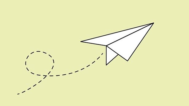 Weißer Papierflieger auf hellgrünem Hintergrund