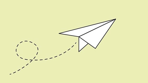 Weißer Papierflieger auf hellgrünem Hintergrund