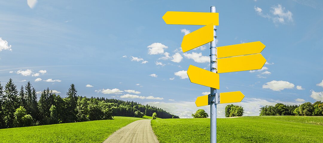 Landschaftsfoto mit Weg und Wegweiserschild