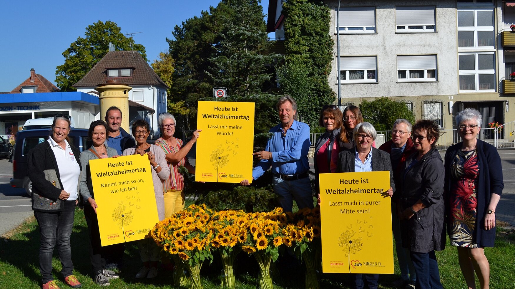 Zu sehen sind die Mitglieder des Aktionsbündnisses Demenz Singen/Hegau, Vasen mit Sonnenblumen und den gelben Plakaten zum Weltalzheimertag