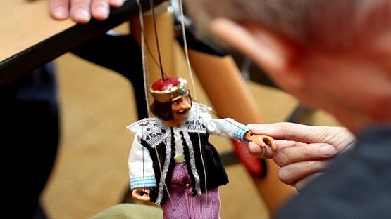 Foto: Eine ältere Person mit einer Marionette.