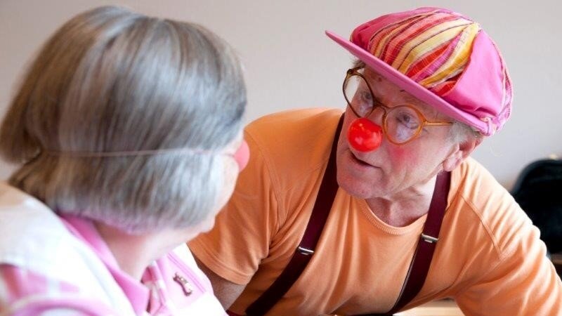 Der Clown Penny Pensky besucht Bewohnerinnen und Bewohner des Stiftungsdorfs Hollergrund Foto: Ein Mann verkleidet als Clown und eine ältere Dame.